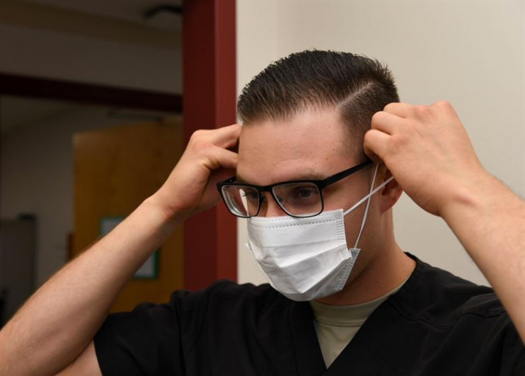 Sacramento doctor putting on COVID-19 face mask